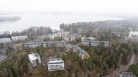 Ilmakuvassa näkyy ilmasta kuvattuna useita taloyhtiöitä ja meri taustalla.