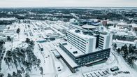 Kuvassa on talvinen maisema, jossa näkyy suuri sairaalarakennus lumisessa ympäristössä. Rakennus on OYS, eli Oulun yliopistollinen sairaala, joka sijaitsee Oulussa, Suomessa. Uusi rakennus kuvan edessä, takan vanha sairaala joka puretaan.