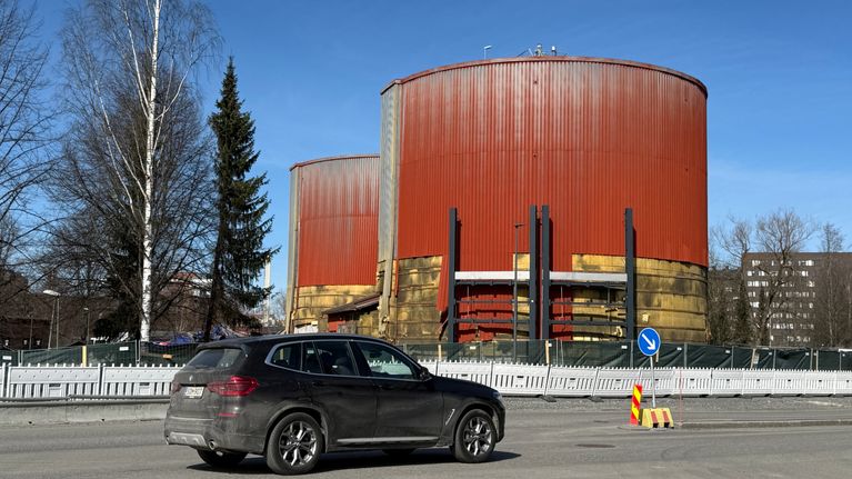 Viinikanlahden jätevedenpuhdistamon purkutyömaalla lieriömuotoiset mädättämörakennukset Hatanpään valtatiellä, henkilöauto etualalla.