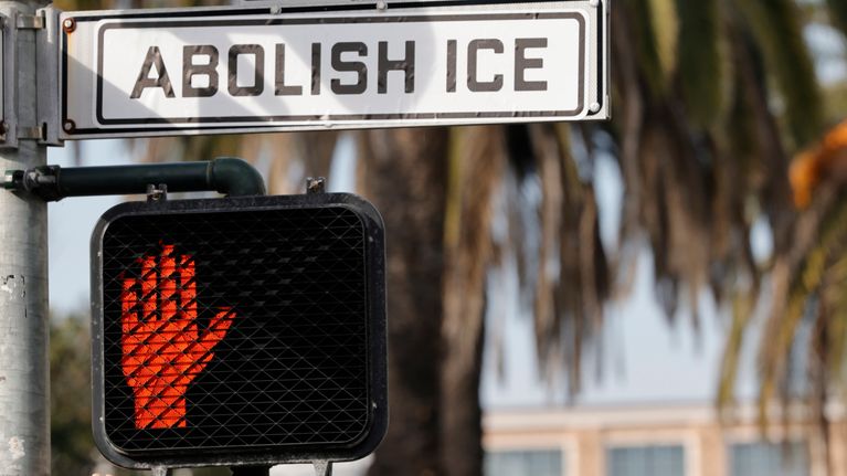 Mielenosoittajien laittama ABOLISH ICE eli LAKKAUTTAKAA ICE -tarra katukyltin päällä.