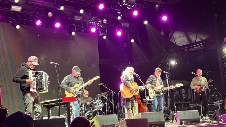 Emmylou Harris med band på scen. Spelar fjol och dragspel bland annat.