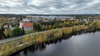 järvi ja ruska metsää. Kemijärven keskustaa ja kirkko.