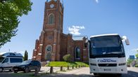 Lovisa kyrka och en turistbuss parkerad framför.