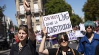 Tre personer under en demonstration för aborträttigheter i Paris.