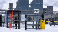 Nainen kävelee ulos Outokummun tehdasalueelta Torniossa