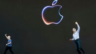 Tim Cook ja Craig Federighi vilkuttavat mustalta lavalta, jossa iso Applen omena logo.