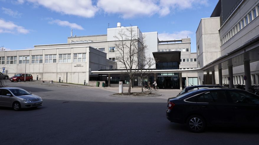 Mikkelin keskussairaalan pihalla on autoja ja ihmisiä aurinkoisena kevätpäivänä.