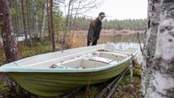 Ari Tolvanen tarkastelee soutuvenettään rannassa.