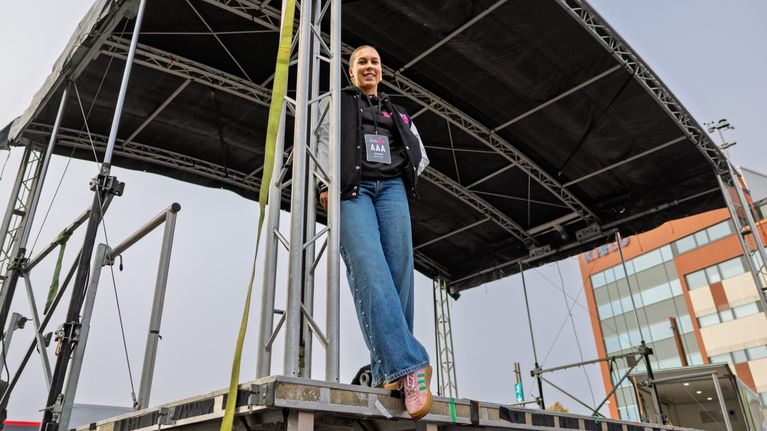 Lisa Elonen seisoo ulkolavan reunalla ja pitää kiinni pilarista.