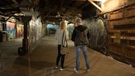 Två personer som ser på graffitikonst