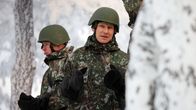 Puolustusministeri Häkkänen armeijan maastopuvussa talvisessa maisemassa.
