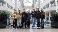 Nuoria seisoo vierekkäin käsi toistensa olalla kauppakeskuksessa.