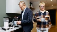 Kaksi henkilöä kahvittelevat työpaikalla.