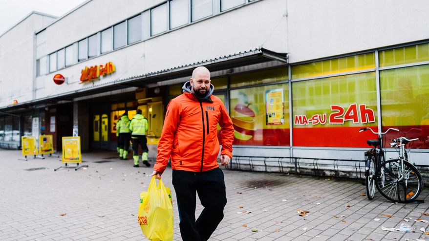 Jarkko Mandelin tulee ulos ruokakaupasta kantaen täyttä keltaista muovikassia.
