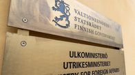 Valtioneuvoston ja ulkoministeriön kyltit talon seinässä.