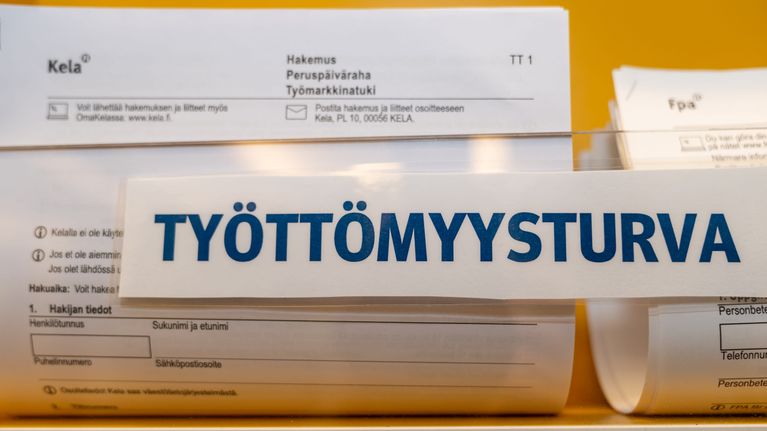 Työttömyysturva-hakemuslomake hyllyssä.