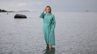Julia Sangervo seisoo rantavedessä sinertävässä mekossa.