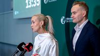 Kaksi ihmistä puhumassa Vihreän puolueen infotilaisuudessa. Naisella on vaaleat hiukset, miehellä lyhyet hiukset.
