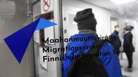 Person seen behind a glass door that features the logo of the Finnish Immigration Service.