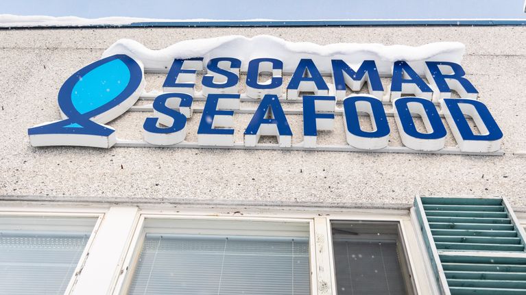 Escamar Seafood -yrityksen kyltti talon seinässä.