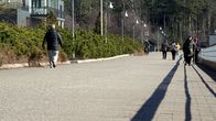 Photo shows people walking on a street.
