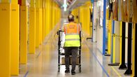 Mies työntää kärryä käytävällä Amazonin logistiikka- ja jakelukeskuksessa Saksan Horn-Bad Meinbergissä 9. joulukuuta 2024.