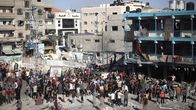 Palestiinalaisia kokoontuneena pihalle kouluun osuneen ilmaiskun jälkeen.