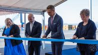Tasavallan presidentti Alexander Stubb ja muita ihmisiä leikkaamassa kangasta saksilla.