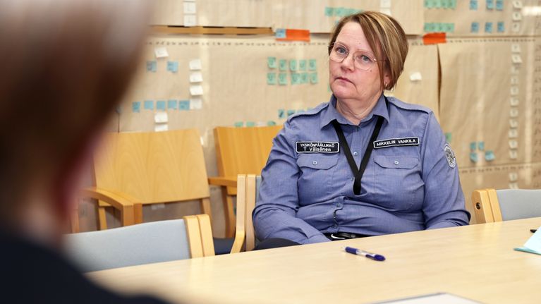Yksikönpäällikkö Tarja Väisänen istuu tuolilla Mikkelin vankilan neuvotteluhuoneessa.