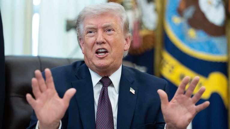Trump istuu työpöytänsä takana Valkoisessa talossa.