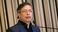 Gustavo Petro seisoo beigen verhon edessä puhumassa mikkiin.