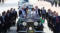 Luiz Inácio Lula da Silva och Geraldo Alckmin står och vinkar i en öppen bil tillsammans med sina fruar. På ömse sidor om bilen springer säkerhetsvakter.