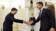 Romanian presidentti Nicusor Dan kättelee leveästi hymyillen Naton pääsihteeri Mark Ruttea. Takana seisoo paraatipukuinen sotilas asennossa.