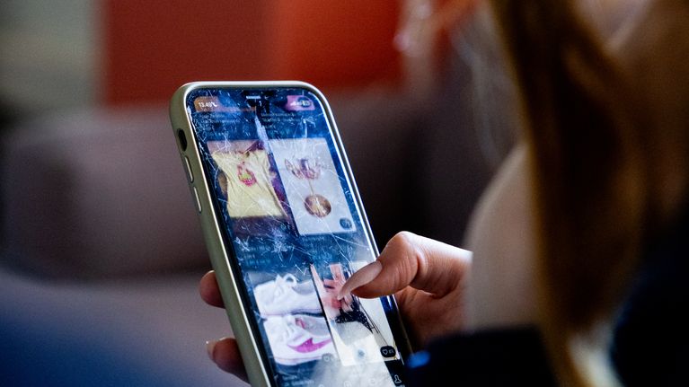 Closeup of a person using a smartphone with one hand.
