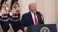 Presidentti Donald Trump pitää puhetta Valkoisessa talossa taustanaan tähtiliput.