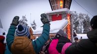 Turistit vilkuttelevat kameralle joulupukin pajakylässä.