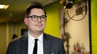 Matti Pesu i grå kostym tittar förbi kameran.