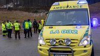 Ambulanssi etualalla, takana vapaaehtoisia ja ensihoitajia. 