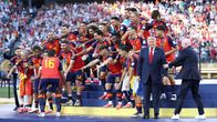 Espanjan joukkue juhlii maailmanmestaruutta pokaalin kanssa, Gianni Infantino ohjaa Donald Trumpia sivummalle.
