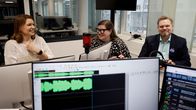 Kolme henkilöä keskustelemassa radiostudiossa mikrofonien ääressä.