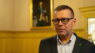 Kaskös Stadsdirektör Markku Lumio står i fullmäktigesalen, i bakgrunden syns en tavla som föreställer Gustav den tredje. 