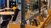 Nainen lukemassa lehteä Iisalmen kirjaston lukusalissa.