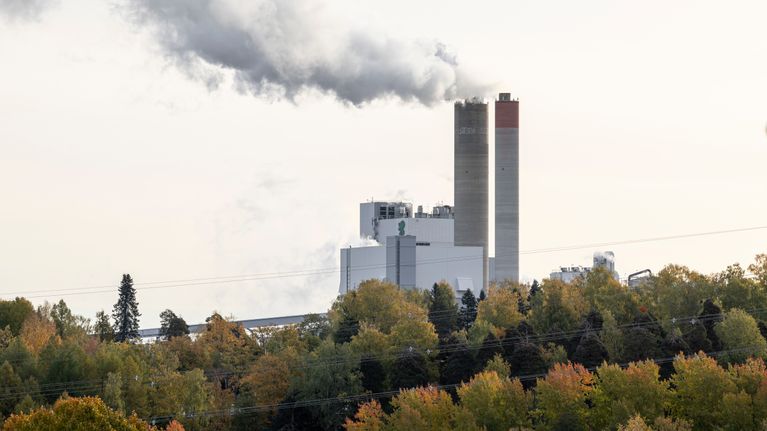 UPM Kaukas ja sen kaksi piippua metsän takana Lappeenrannassa.