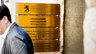 Valtioneuvoston, oikeusministeriön sekä opetus- ja kulttuuriministeriön kyltit rakennuksen sisäänkäynnin vieressä.