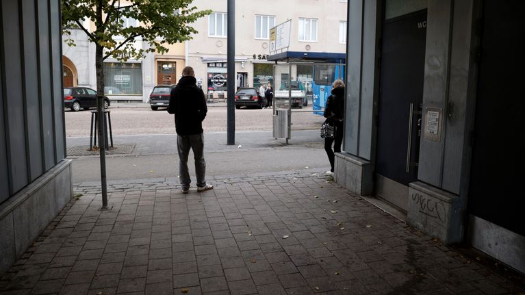 Kaksi nuorta seisovat bussipysäkin edessä Lahden keskustassa.