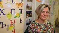 Venäjänopettaja Anne Lindholm Puolalan koulun kieliluokassa. Taustalla venäläisten aakkosten taulu. 