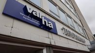 Varhan, eli Varsinais-Suomen hyvinvointialueen kyltti Uudenkaupungin terveyskeskuksen ja sairaalan seinässä pääoven päällä.