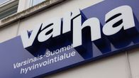 Varhan, eli Varsinais-Suomen hyvinvointialueen kyltti Uudenkaupungin terveyskeskuksen ja sairaalan seinässä pääoven päällä.