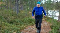 Mikko "Peltsi" Peltola juoksee metsäpolkua pitkin Inarissa Juutuanjoen läheisyydessä yllään verryttelyasu.
