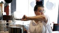Kahvilanpitäjä Anita Lehtinen kaataa kahvia perkolaattoriin.